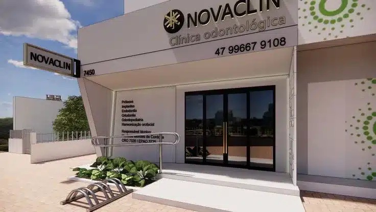 Fachada de clínica odontológica pequena com revestimento claro, tipografia elegante e paisagismo.