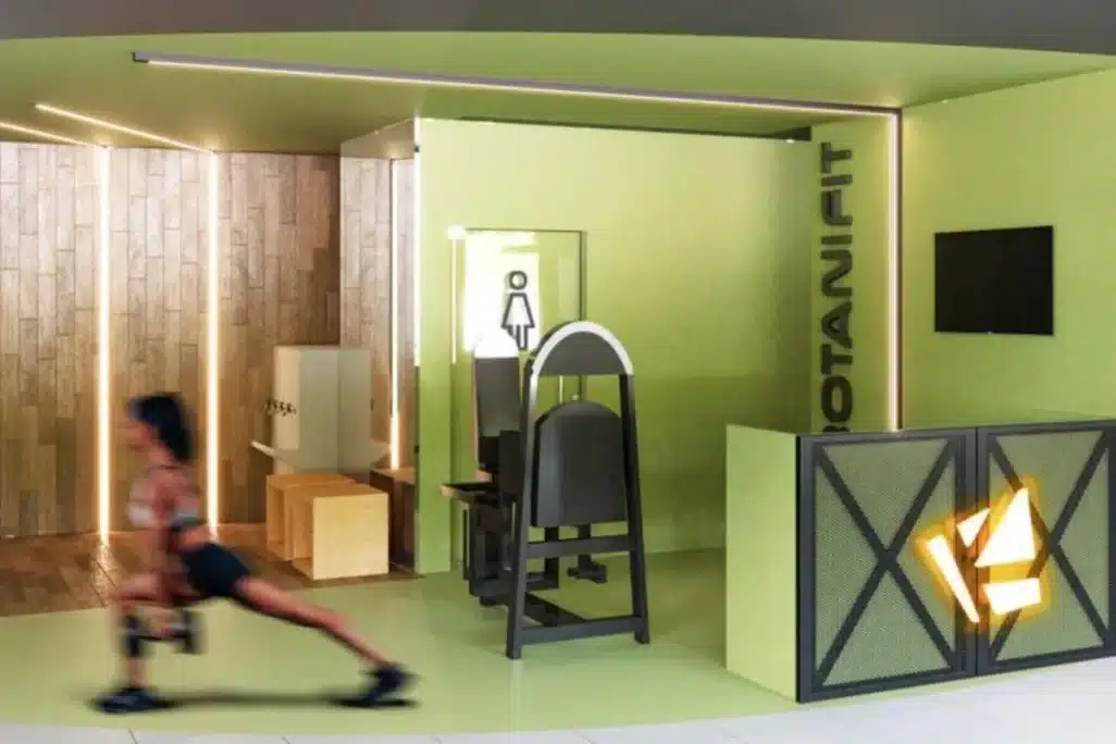 Projeto de academia com recepção moderna, equipamento funcional e design em tons verdes, feito pela Arquiter