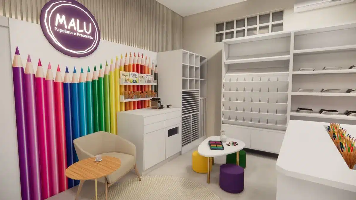 Projeto de papelaria com canto instagramável decorado com parede de lápis de cor gigantes, mobiliário funcional e ambiente que valoriza a experiência do cliente durante a compra.