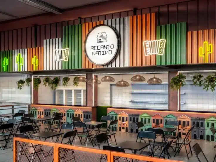 Ambiente de restaurante temático com decoração colorida, mesas coletivas e elementos visuais que valorizam a experiência do cliente. 