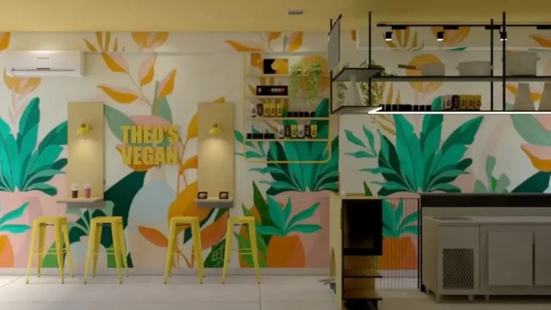 Restaurante temático com decoração em tons de verde na parede, incluindo folhagens pintadas, detalhes coloridos e design moderno que reforça a identidade visual do espaço.