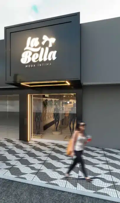Fachada de loja de moda pequena "La Bella Moda Íntima" com letreiro luminoso e vitrine minimalista