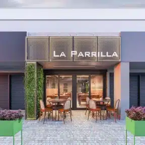 fachada comercial pequena do restaurante La Parrilla com jardim vertical e mesas externas